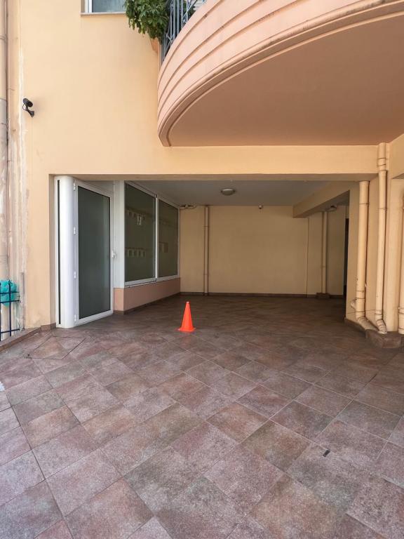an empty parking lot with an orange cone in front of a building at Αγρίνιο κέντρο ΔΣ, Δ1 in Agrinio