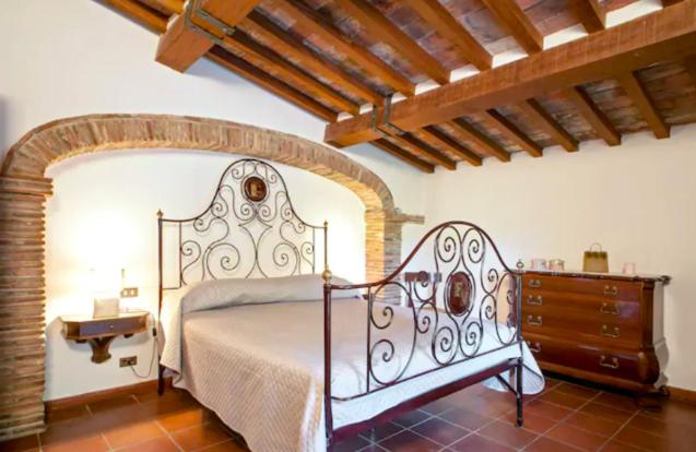 een slaapkamer met een groot bed en een dressoir bij Fattoria Uccelliera in Lorenzana