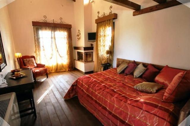 - une chambre avec un grand lit rouge et un bureau dans l'établissement Nastou View Hotel, à Ano Poroia