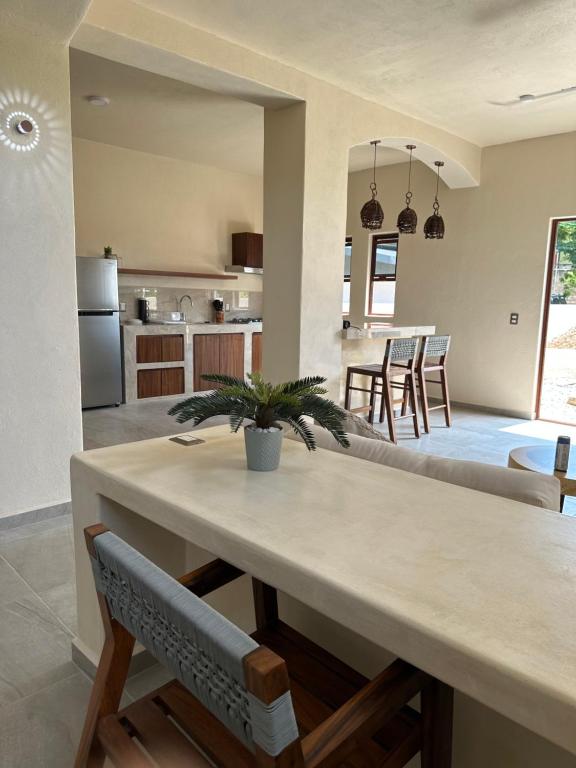 ein Esszimmer und eine Küche mit Tisch und Stühlen in der Unterkunft Casa blanca playa saladita in Temalhuacán