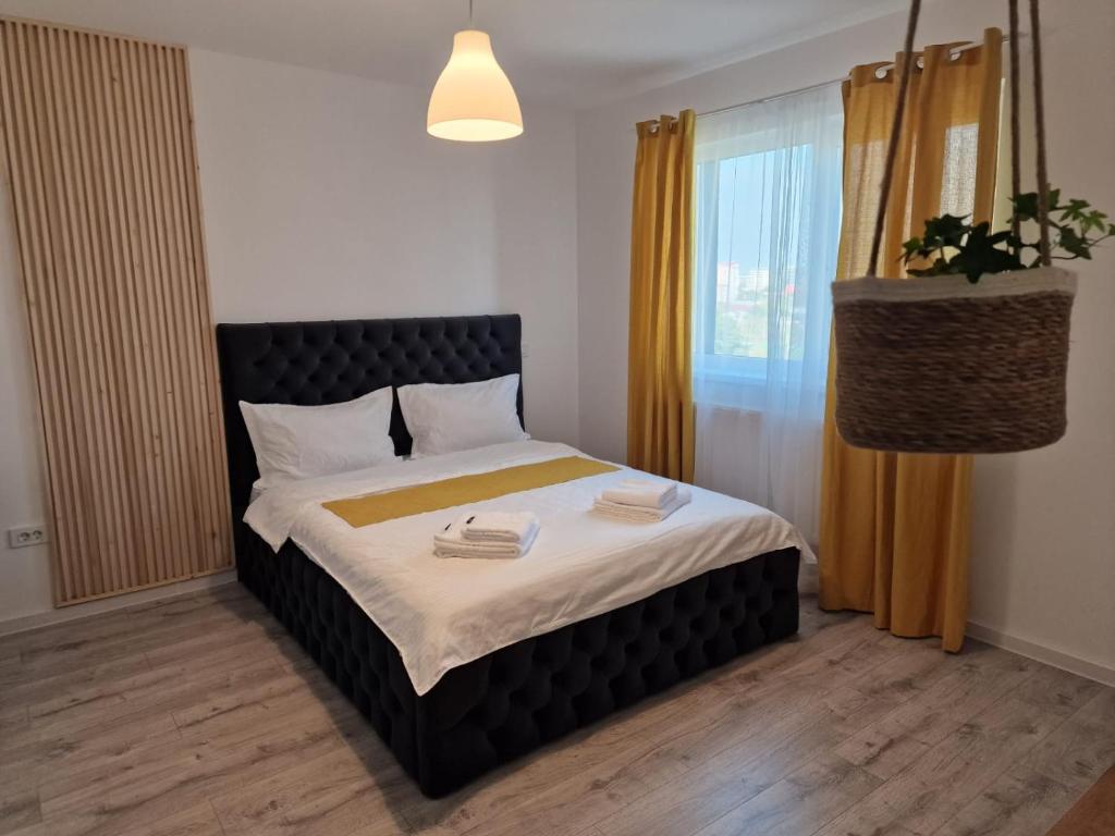 een slaapkamer met een bed met twee handdoeken erop bij Luxury Grey Apartments in Iaşi