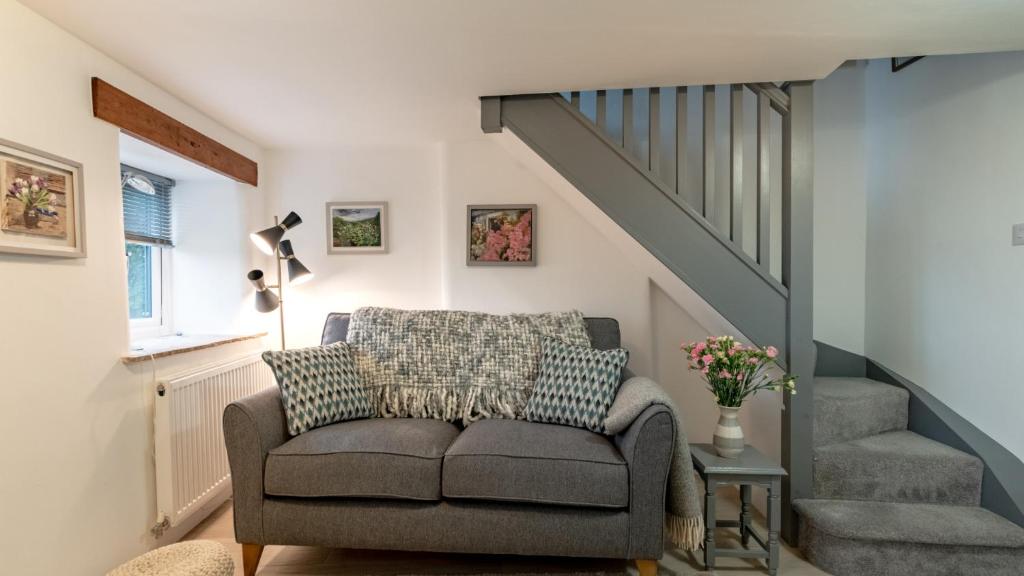 a living room with a couch and stairs at Little Hillside in Ashover