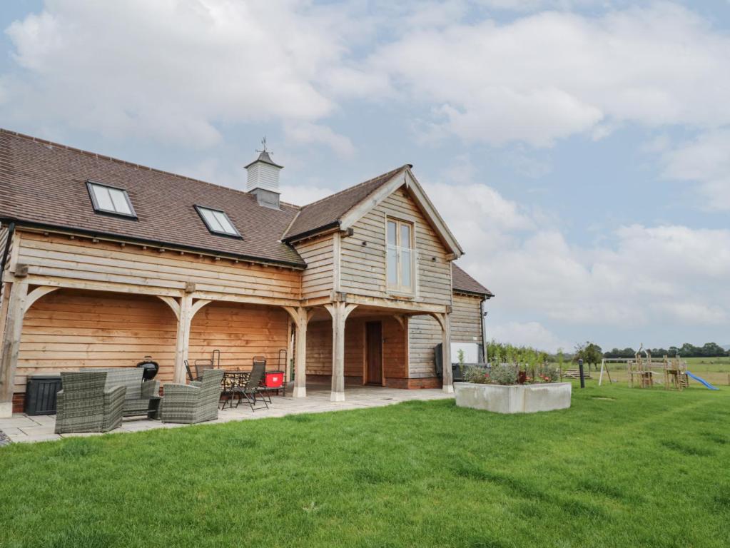 a log home with a patio and lawn at Hallgarth Farm Holiday Lodge in Pershore