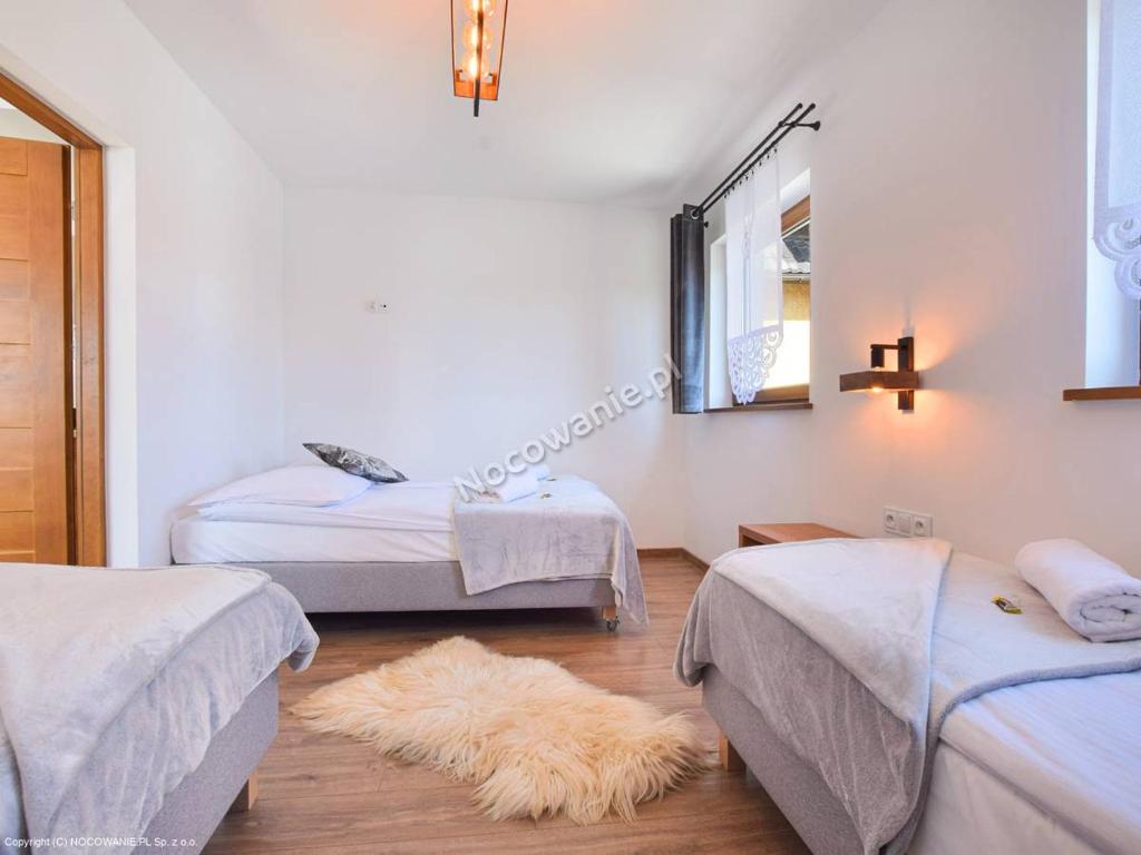 een slaapkamer met 2 bedden en een harig tapijt bij Apartamenty u Petuski in Szaflary