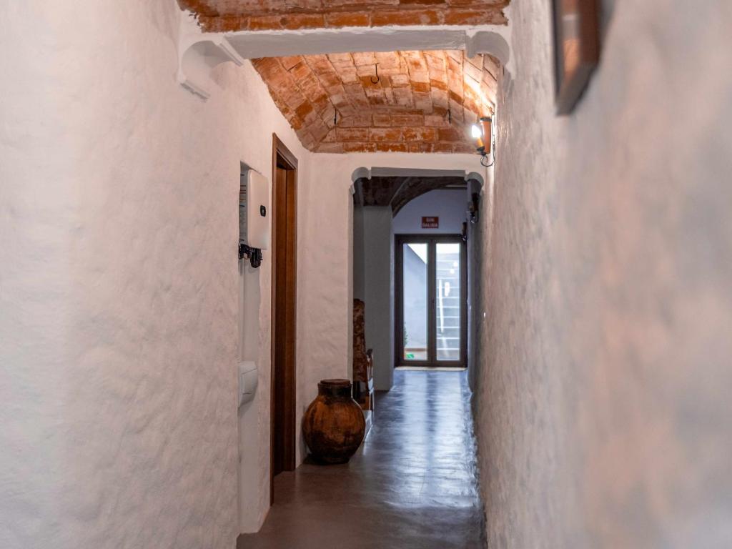 un pasillo con paredes blancas y techo de madera en Casa Rural El Palomeque 