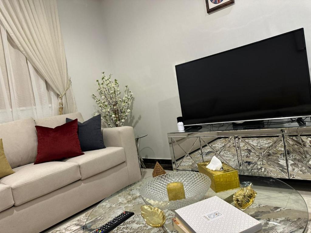 a living room with a couch and a flat screen tv at Luxury apartment in a tower شقه فاخرة في برج اللؤلؤة in Riyadh
