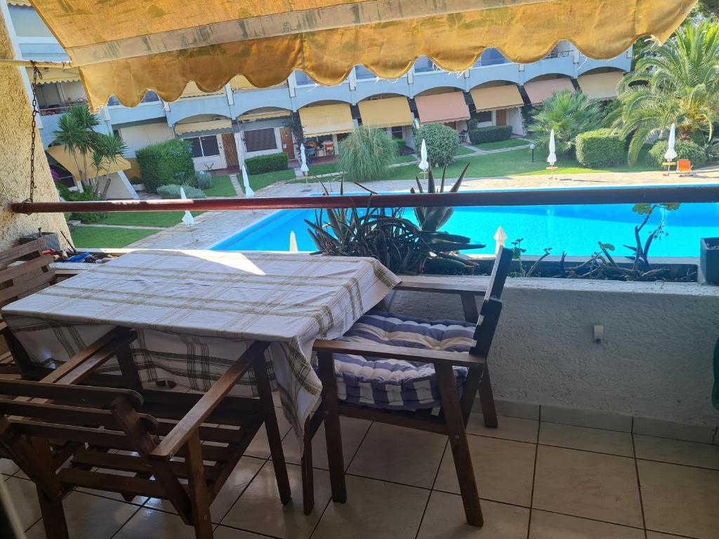 a table and chairs on a patio with a swimming pool at MIRAMARE in Nea Makri