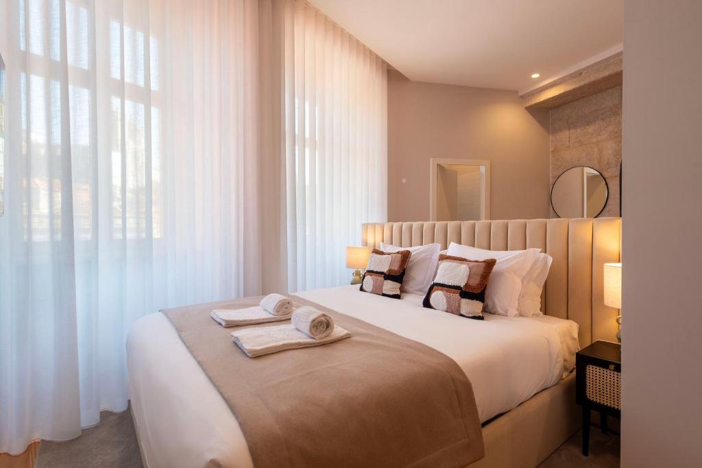 um quarto com uma cama grande e toalhas em Ando Living - Flores Townhouse no Porto