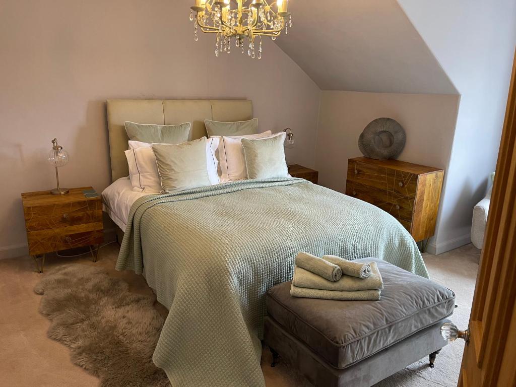 a bedroom with a large bed and a chandelier at River View in Dumfries