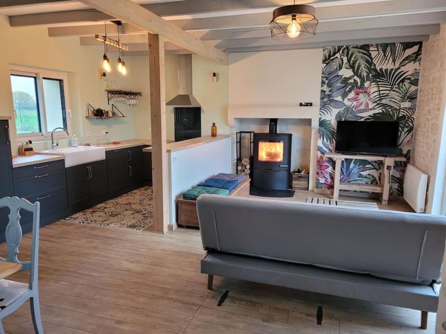 a large living room with a couch and a fireplace at Maison Poitevine 9/10 personnes in Chaunay