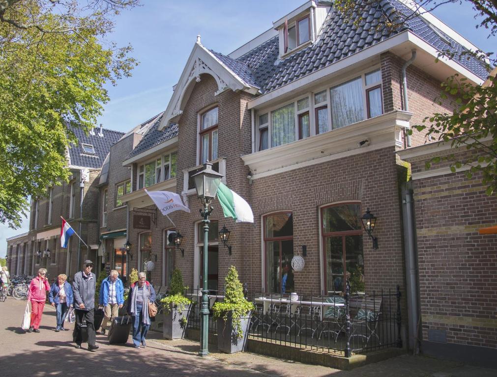 Un groupe de personnes marchant devant une maison dans l'établissement Loods Hotel Vlieland, à Oost-Vlieland