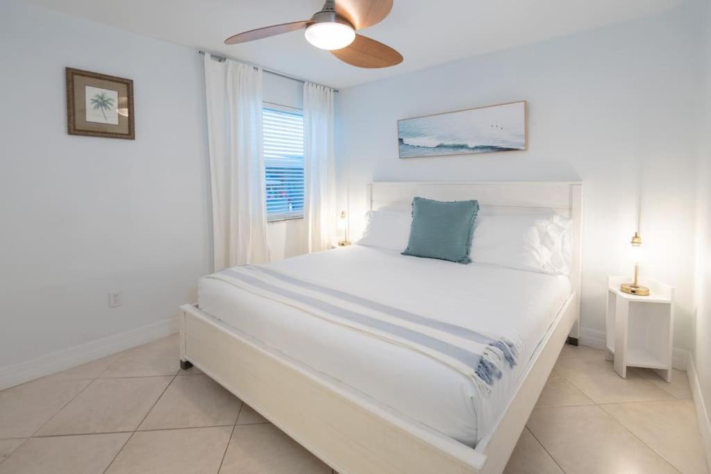 a white bedroom with a white bed and a window at Secluded Beachfront Vibes - Surf & Pet Friendly in Fort Pierce