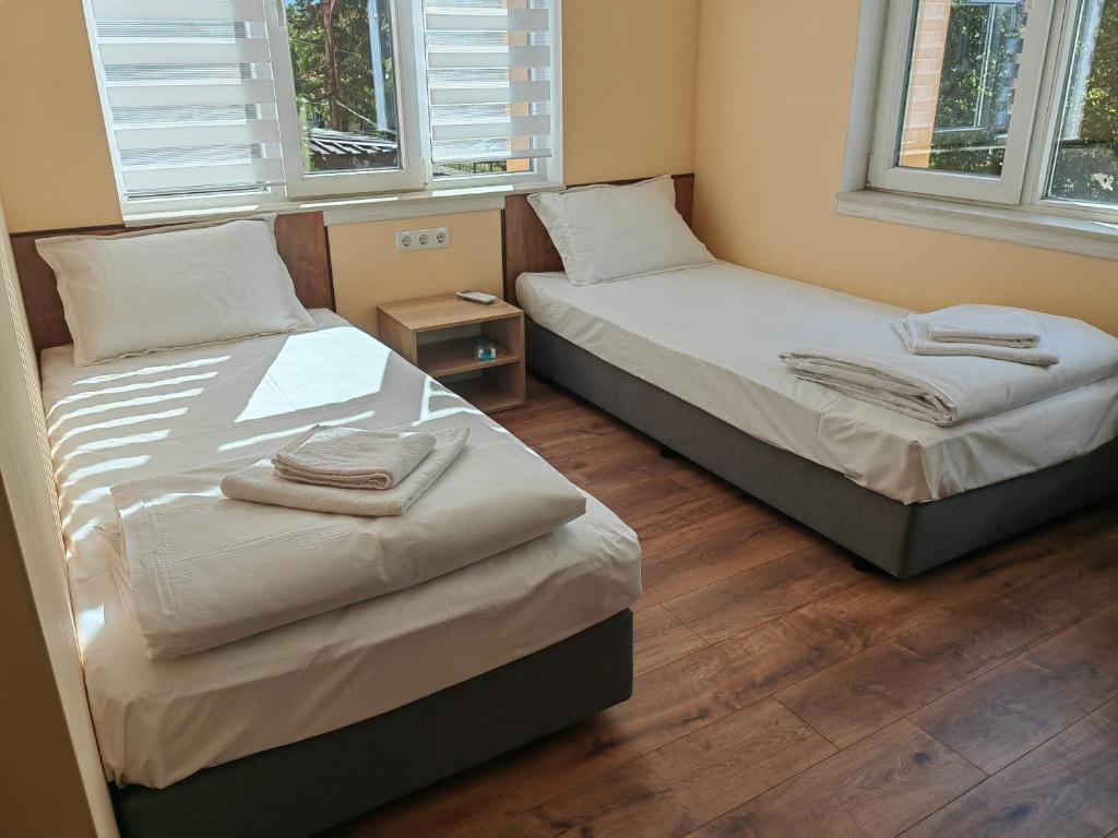 Habitación con 2 camas individuales y 2 ventanas. en стаи за гости TODA, en Troyan