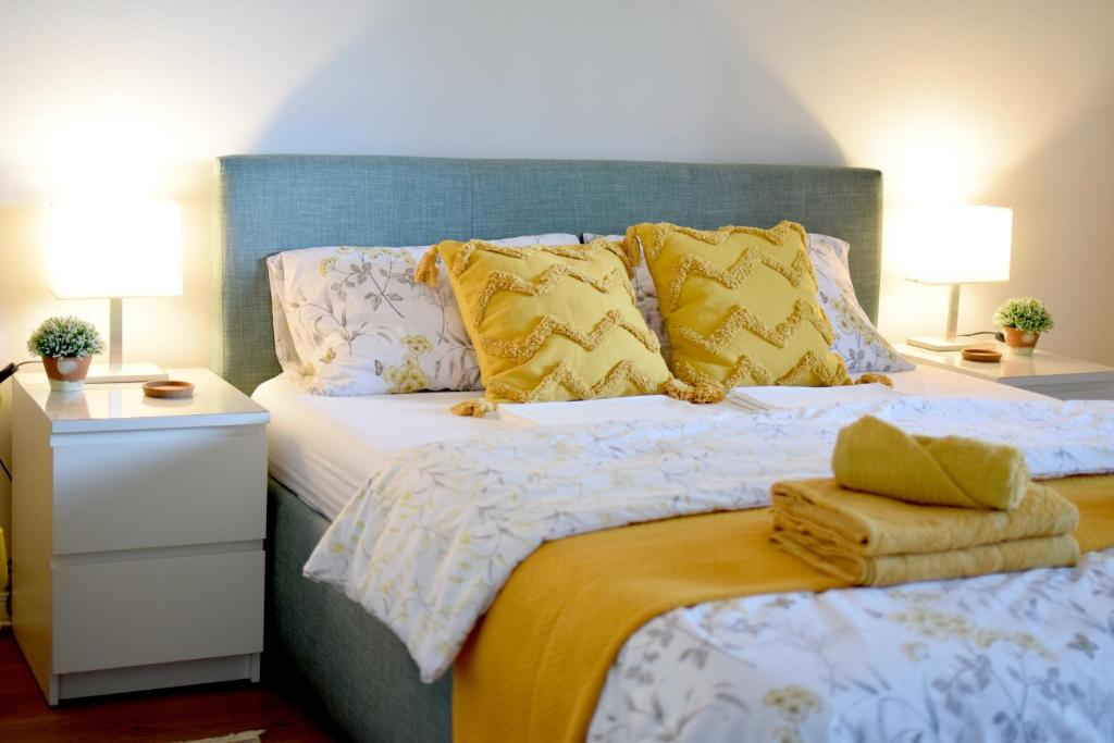 - une chambre avec un grand lit et des oreillers jaunes dans l'établissement Studio Apartman Iva, à Subotica