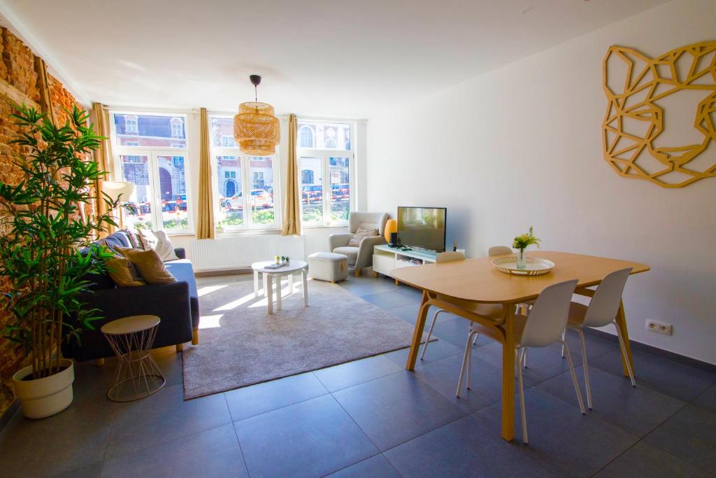 ein Wohnzimmer mit einem Tisch und einem Sofa in der Unterkunft Residence Royal Sélys Terrace, City-Center - Bike Park in Lüttich