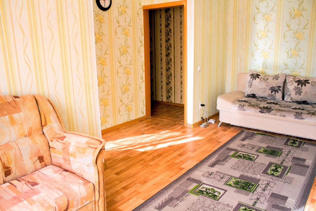 ein Wohnzimmer mit einem Sofa und einem Stuhl in der Unterkunft Нью-Йорк in Petropawlowsk