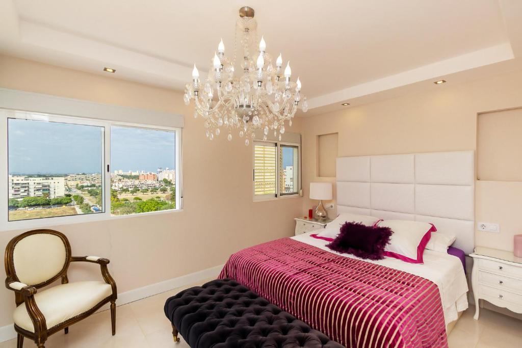 Un dormitorio con una cama grande y una lámpara de araña. en The White Apartment: Luxury, Beach and Design, en Valencia
