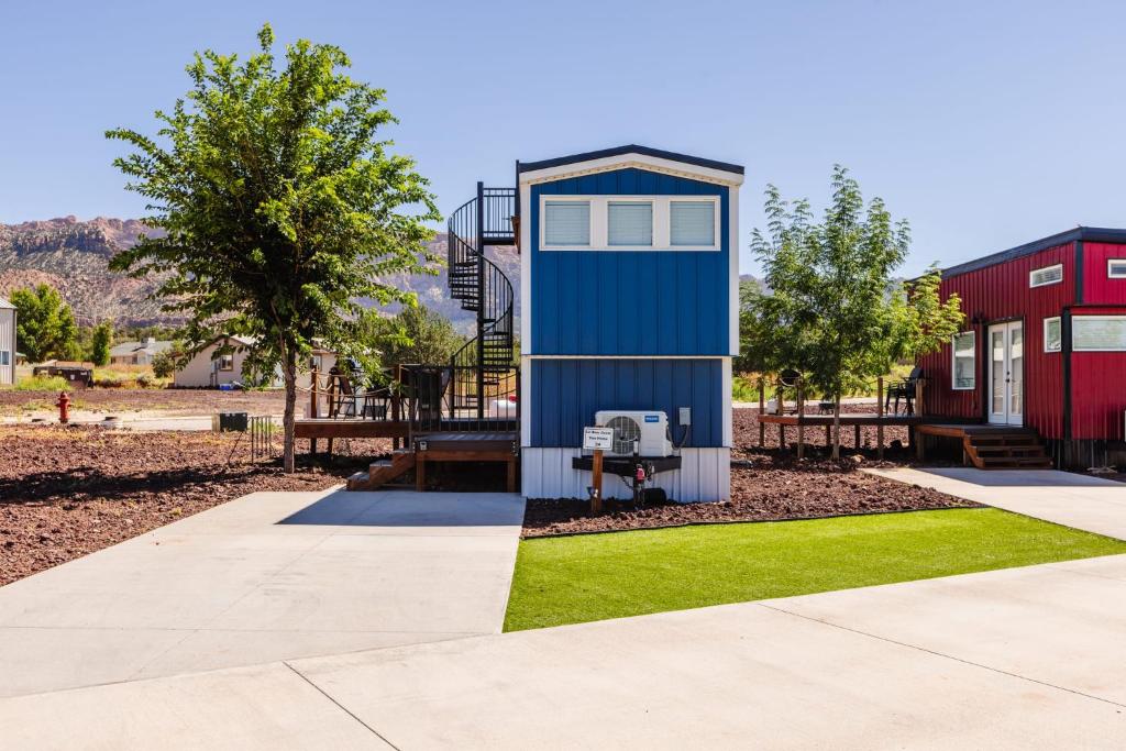 une petite maison dans un parc avec une aire de jeux dans l'établissement Lil' Blue Oasis Tiny Home, à Apple Valley