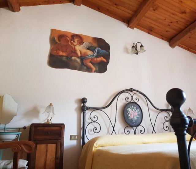 1 dormitorio con 1 cama con una pintura en la pared en B&B La Rocca en San Nicola Manfredi