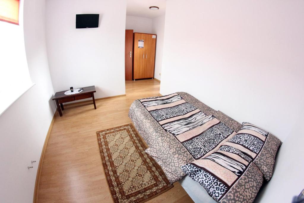 a bedroom with two beds in a room with a table at Rafaello Pokoje Gościnne in Łagów