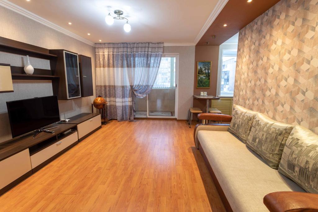 a living room with a couch and a flat screen tv at Палермо in Petropavlovsk