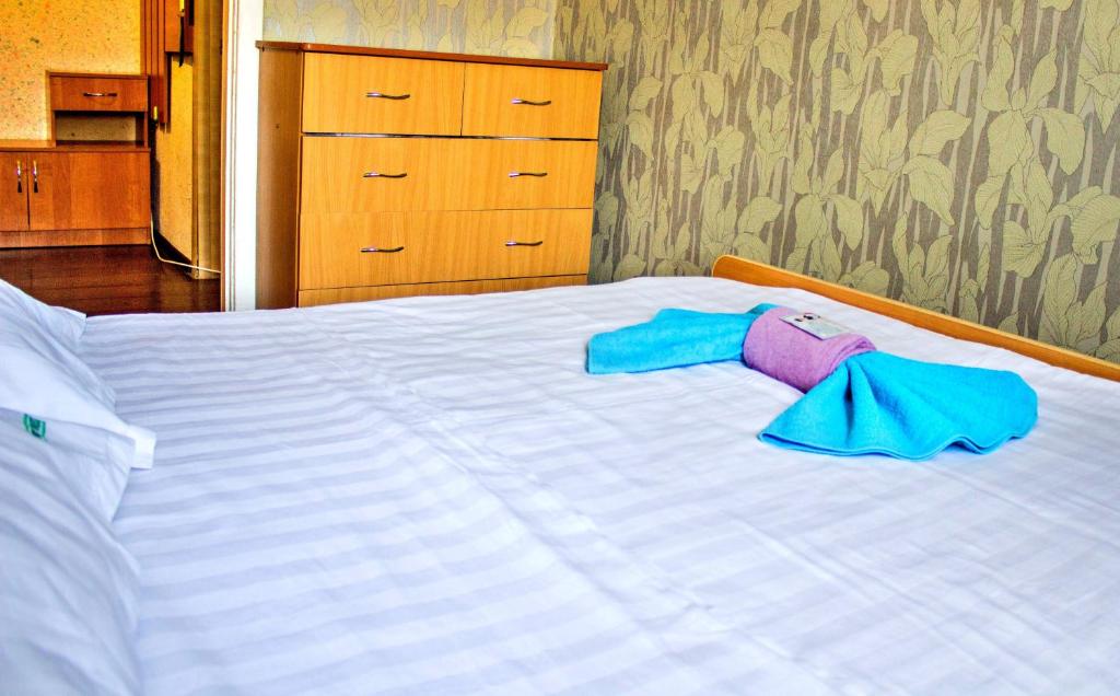 a white bed with blue and pink towels on it at Панама in Petropavlovsk