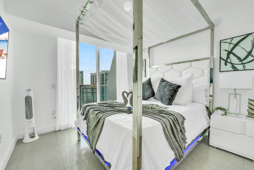 a white bedroom with a canopy bed and a window at Modern 2 Story Loft 2BR with Breathtaking Views in Miami