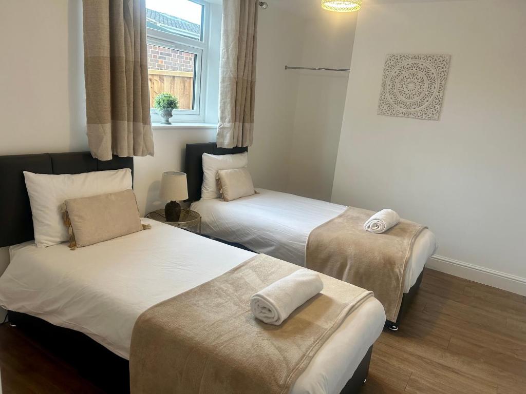 ein Schlafzimmer mit 2 Betten und Handtüchern darauf in der Unterkunft Parkside Apartment in Norwich