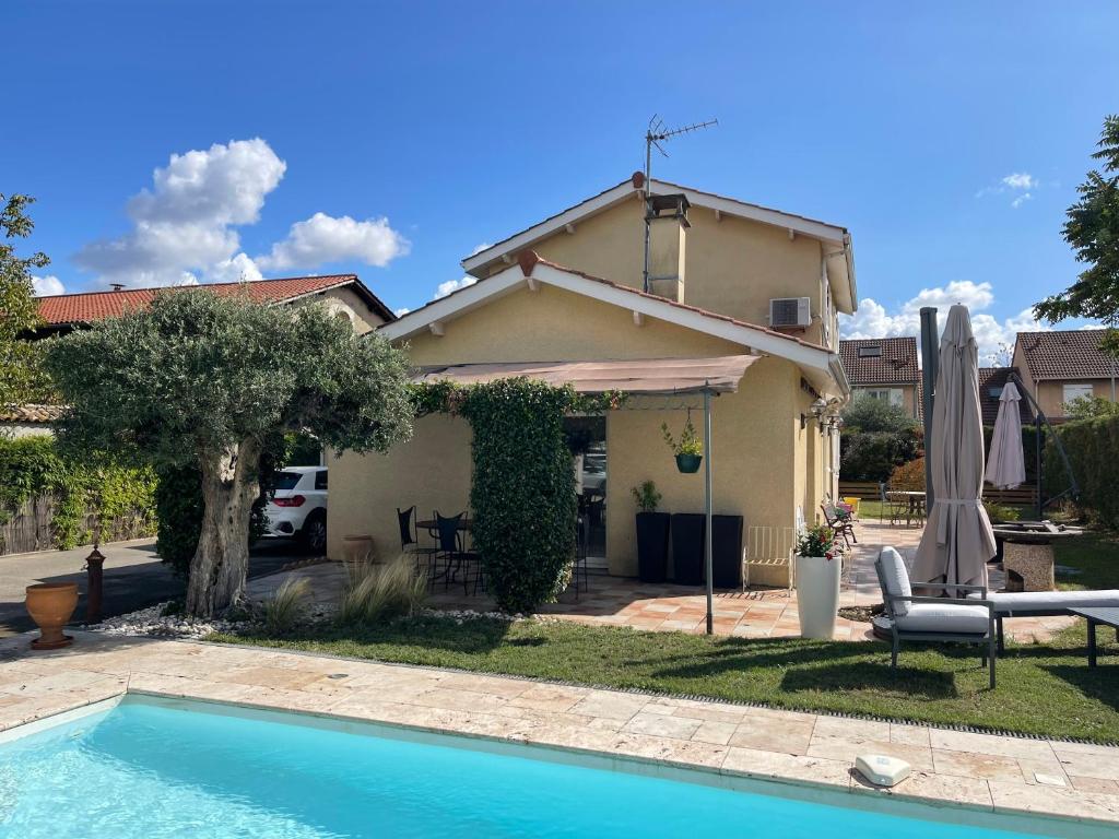 ein Haus mit einem Pool vor einem Haus in der Unterkunft Villa individuelle - CHASSIEU in Chassieu