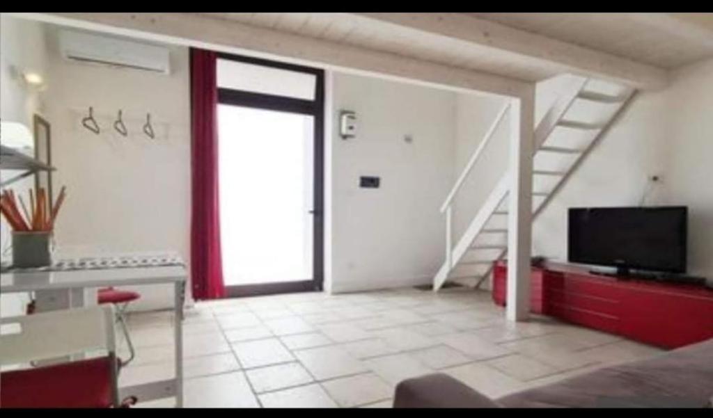 sala de estar con puerta corredera de cristal y TV en Maestrale Holiday Home, en Brindisi