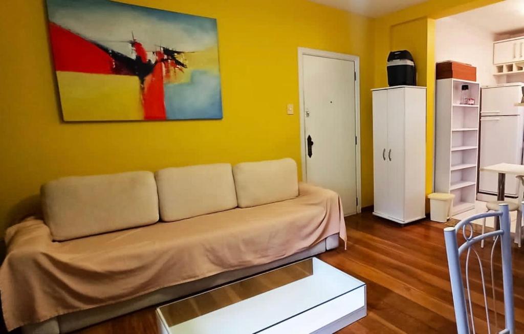 a living room with a couch and a painting on the wall at Apartamento Avenida Atlântica in Rio de Janeiro