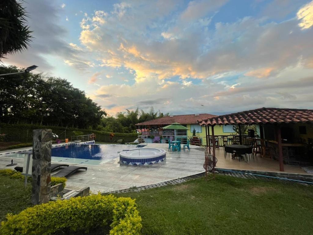 a backyard with a swimming pool and a house at Encanto Cafetero Montenegro in Pueblo Tapao