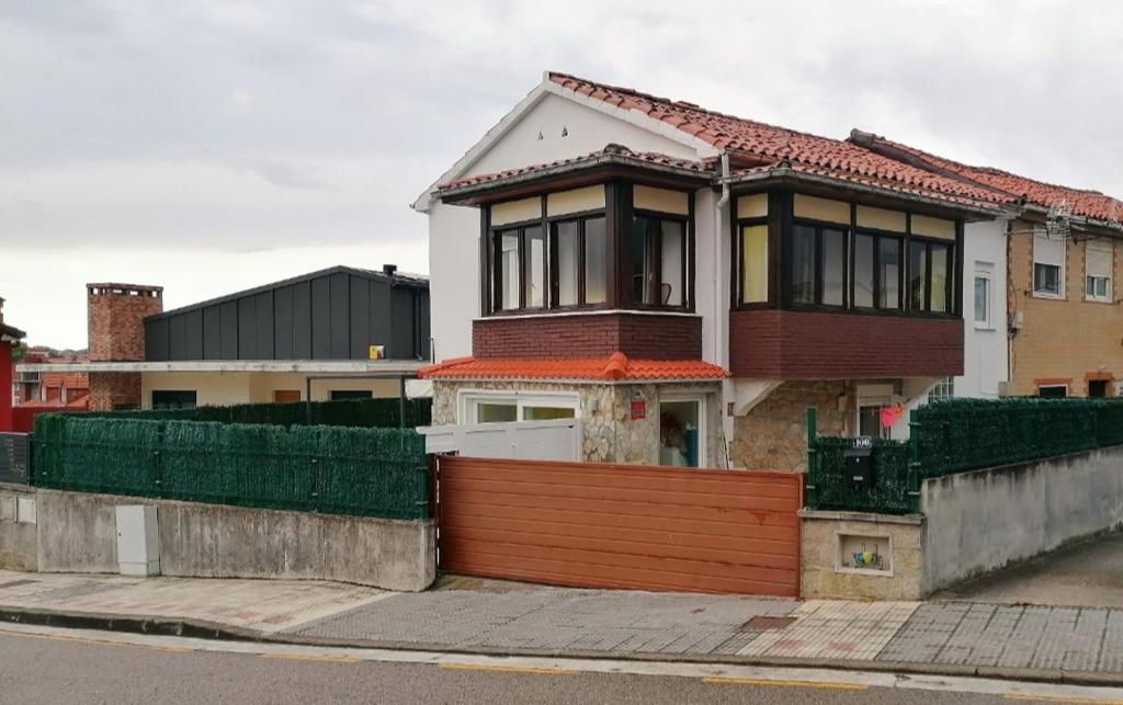 una casa con una valla delante de ella en Estudio con terraza en Guarnizo, en El Astillero