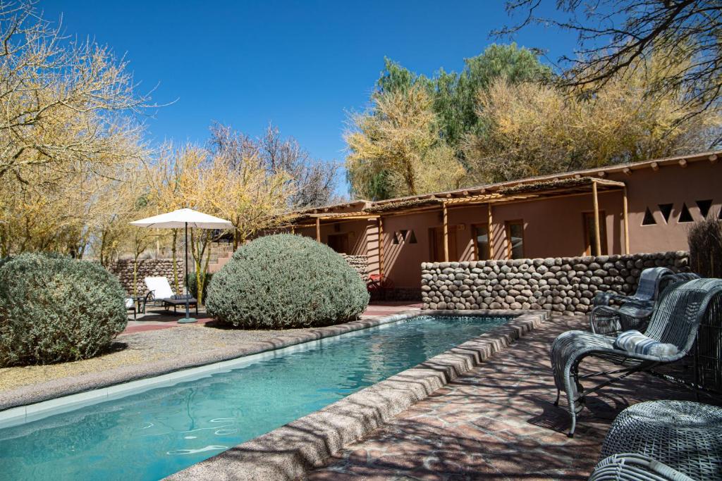 a swimming pool in the yard of a house at Naturalis Hotel in San Pedro de Atacama