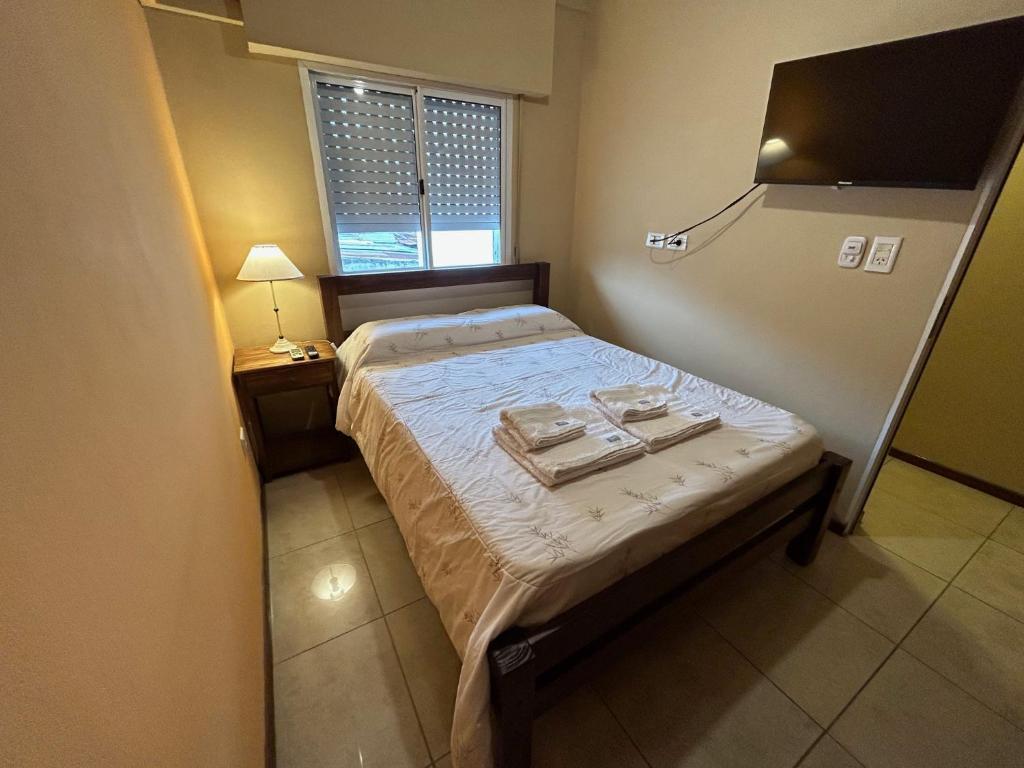um pequeno quarto com uma cama com duas bandejas em Departamento Céntrico bis em Goya