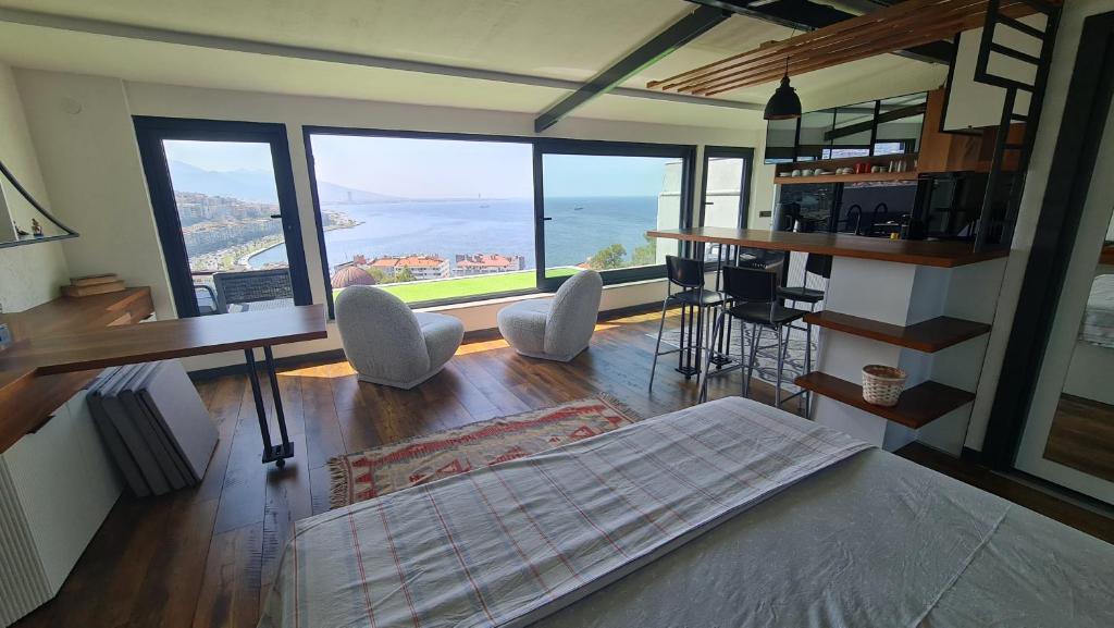 a bedroom with a bed and a view of the ocean at Fascinating Sea View in İzmir