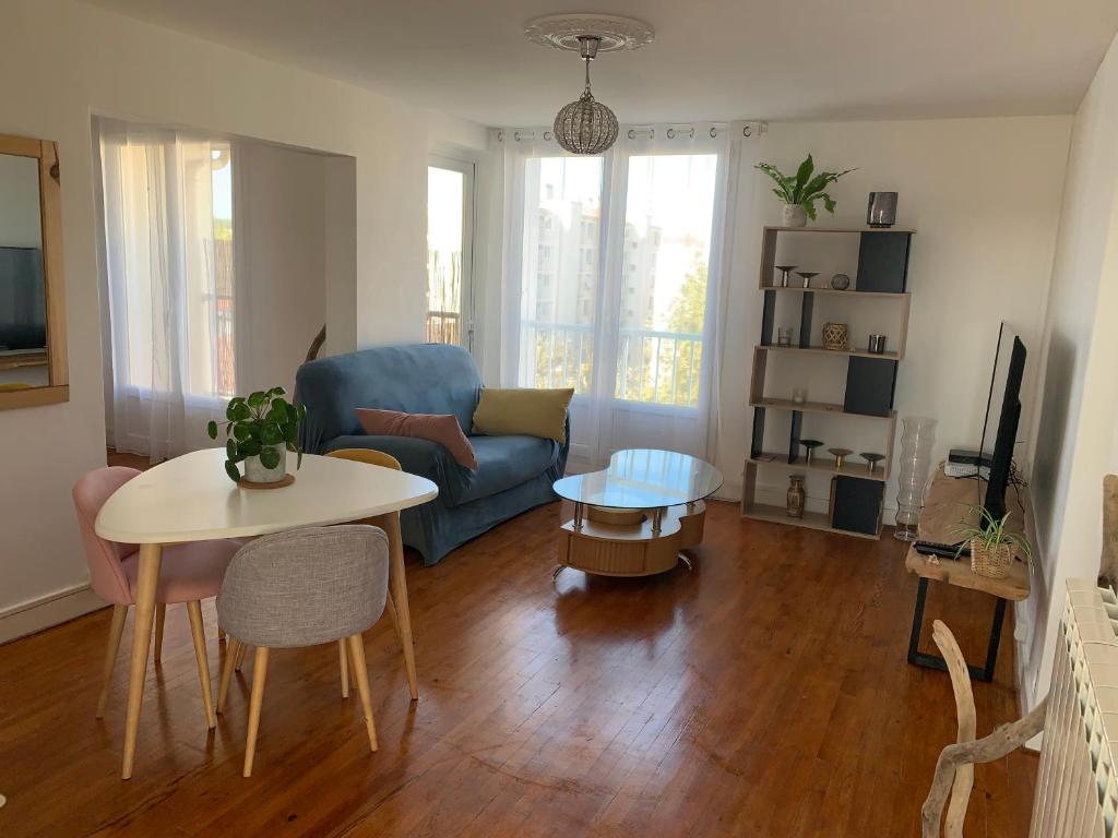 a living room with a blue couch and a table at Appartement T3 Anglet 67m2 in Anglet