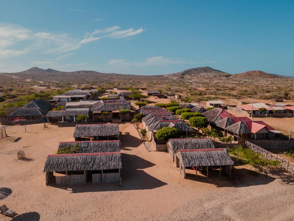 an aerial view of a group of huts in the desert at Rancheria Utta in Cabo de la Vela