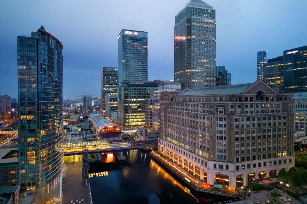 vistas a la ciudad por la noche con rascacielos en Marriott Executive Apartments London, Canary Wharf en Londres