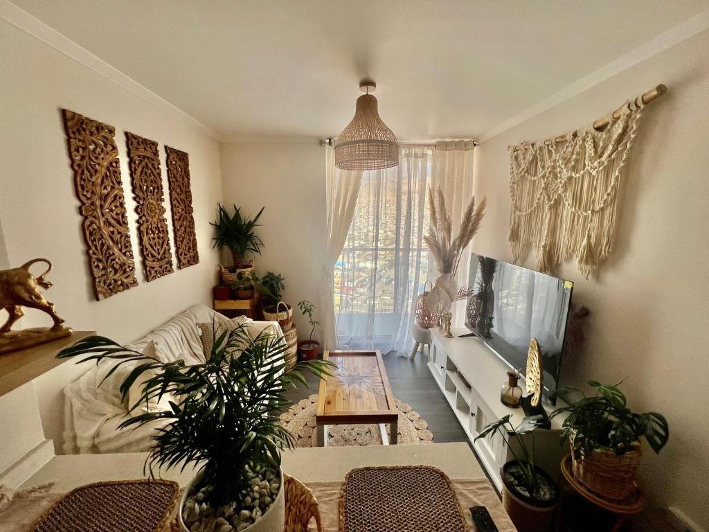 een woonkamer met een bank en een tv bij Acogedor espacio de descanso in Antofagasta