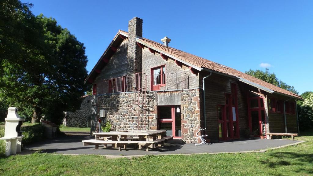 a building with a picnic table in front of it at Le Gîte du Velay in Bains