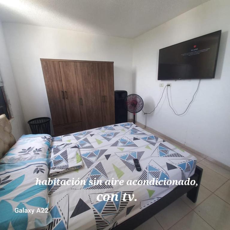 a bedroom with a bed and a flat screen tv at HABITACION EN APARTAMENTO COMPARTIDO - VENTILADOR in Valledupar