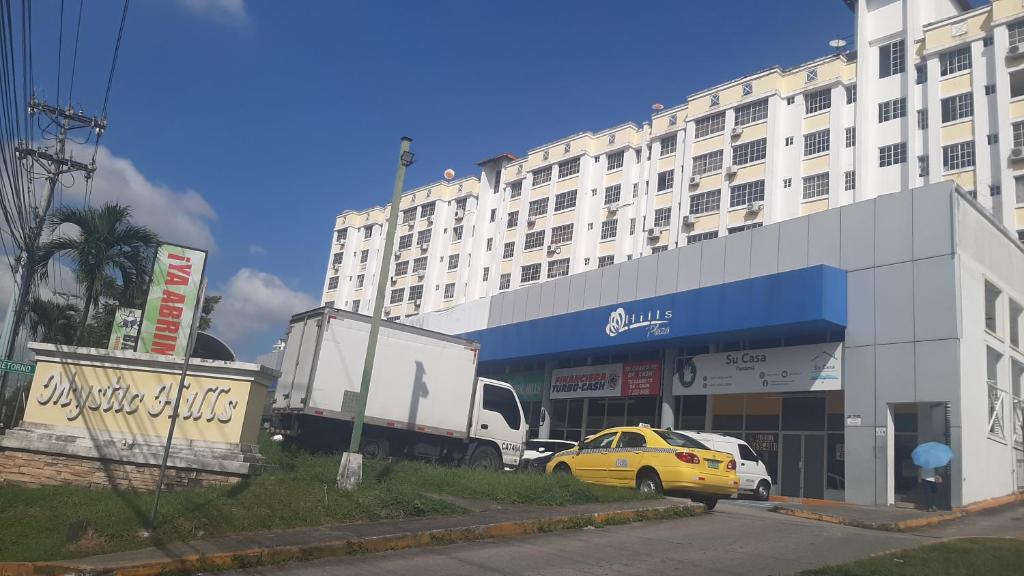 a yellow car parked in front of a large building at APARTAMENTO 3 habitaciones y piscina a solo 15 minutos del aeropuerto in Panama City