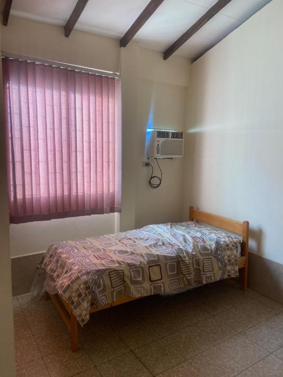 a bedroom with a bed and a window with a heater at Carlos Espinoza Larrea , Atras de Agua pen in Salinas