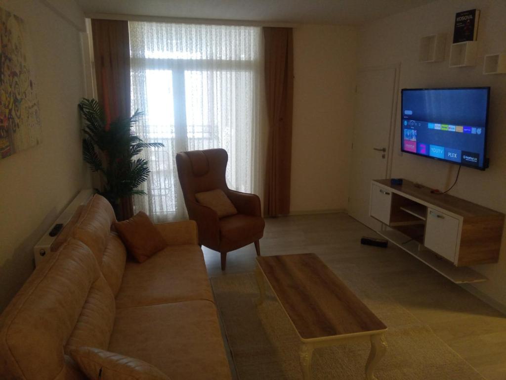 een woonkamer met een bank en een televisie bij URBAN1 Ferizaj City in Ferizaj