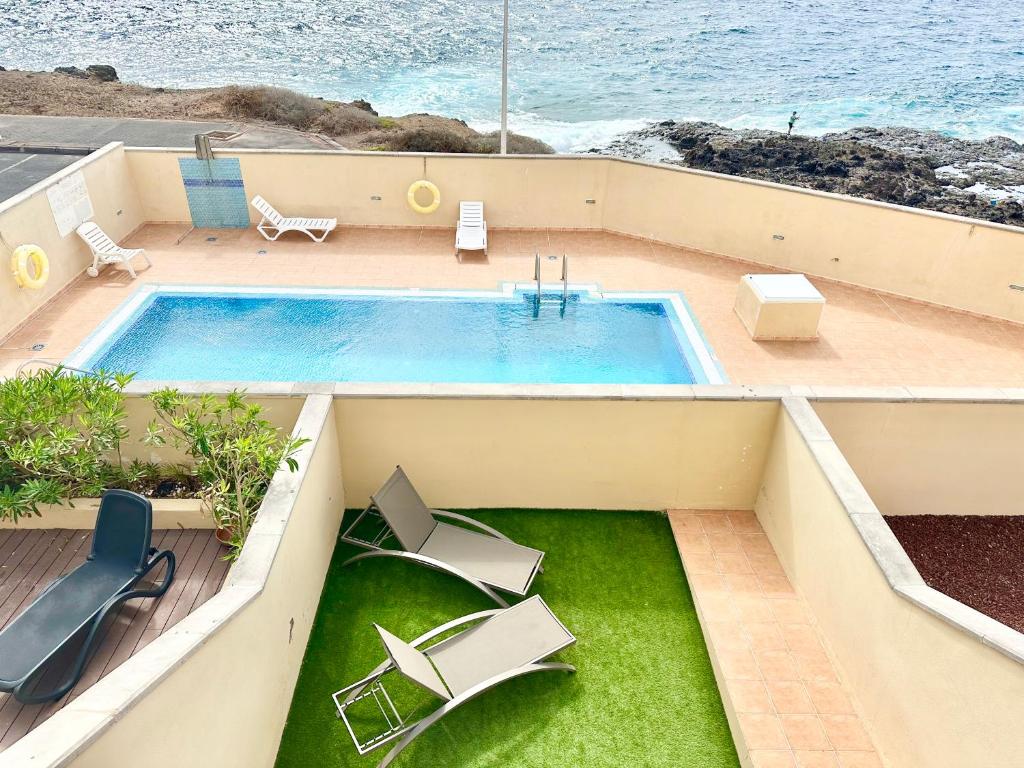una piscina in cima a un edificio vicino all'oceano di Sunny Beach Villa - El Medano a El Médano