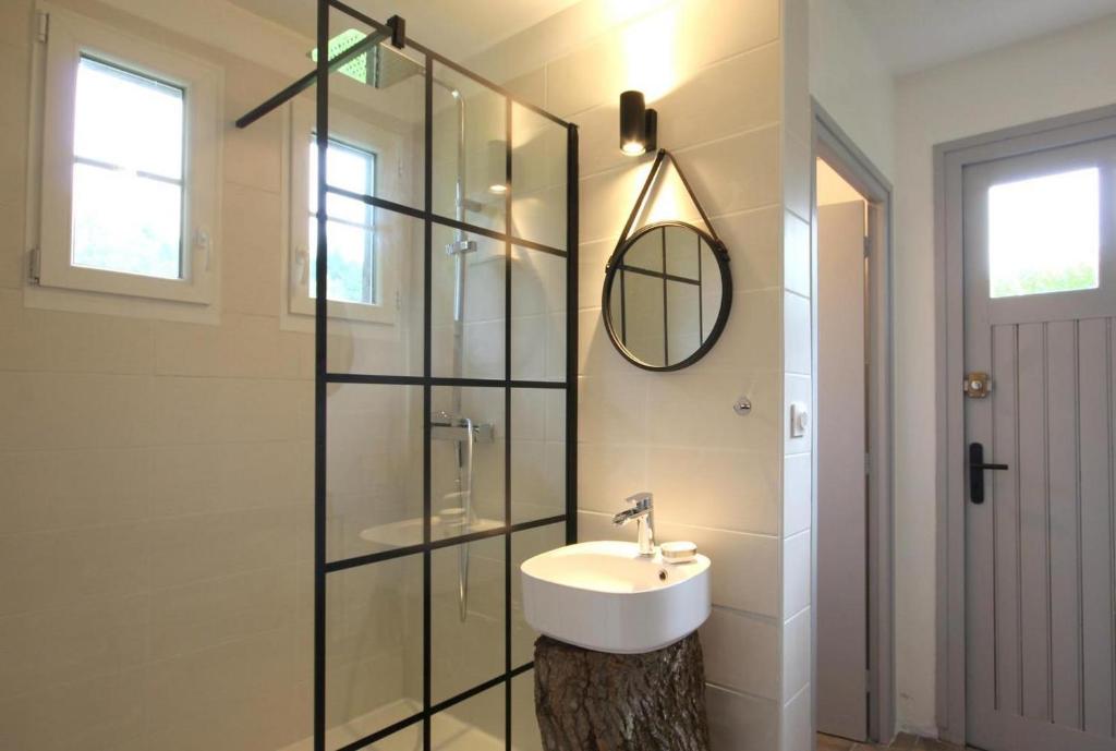a bathroom with a sink and a glass shower at L&#39;Atelier à l&#39;orée des bois in Saint-Pierre-sur-Dives