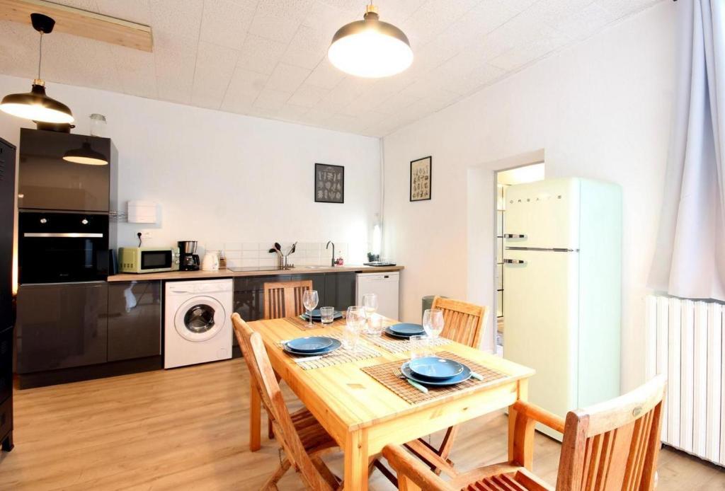 a kitchen and dining room with a wooden table and chairs at L&#39;Atelier à l&#39;orée des bois in Saint-Pierre-sur-Dives