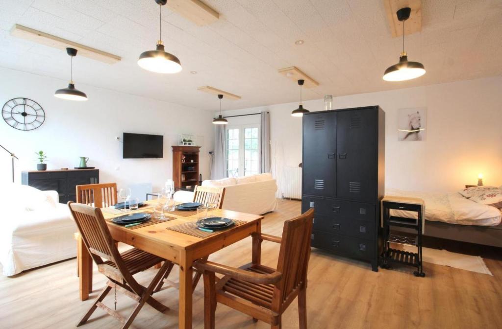 a living room with a table and chairs and a bedroom at L&#39;Atelier à l&#39;orée des bois in Saint-Pierre-sur-Dives