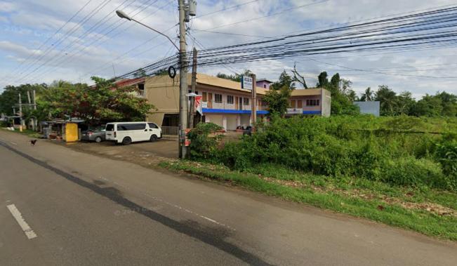 una calle con una furgoneta blanca estacionada al lado de una carretera en ABEJJEE Motel en Panglao